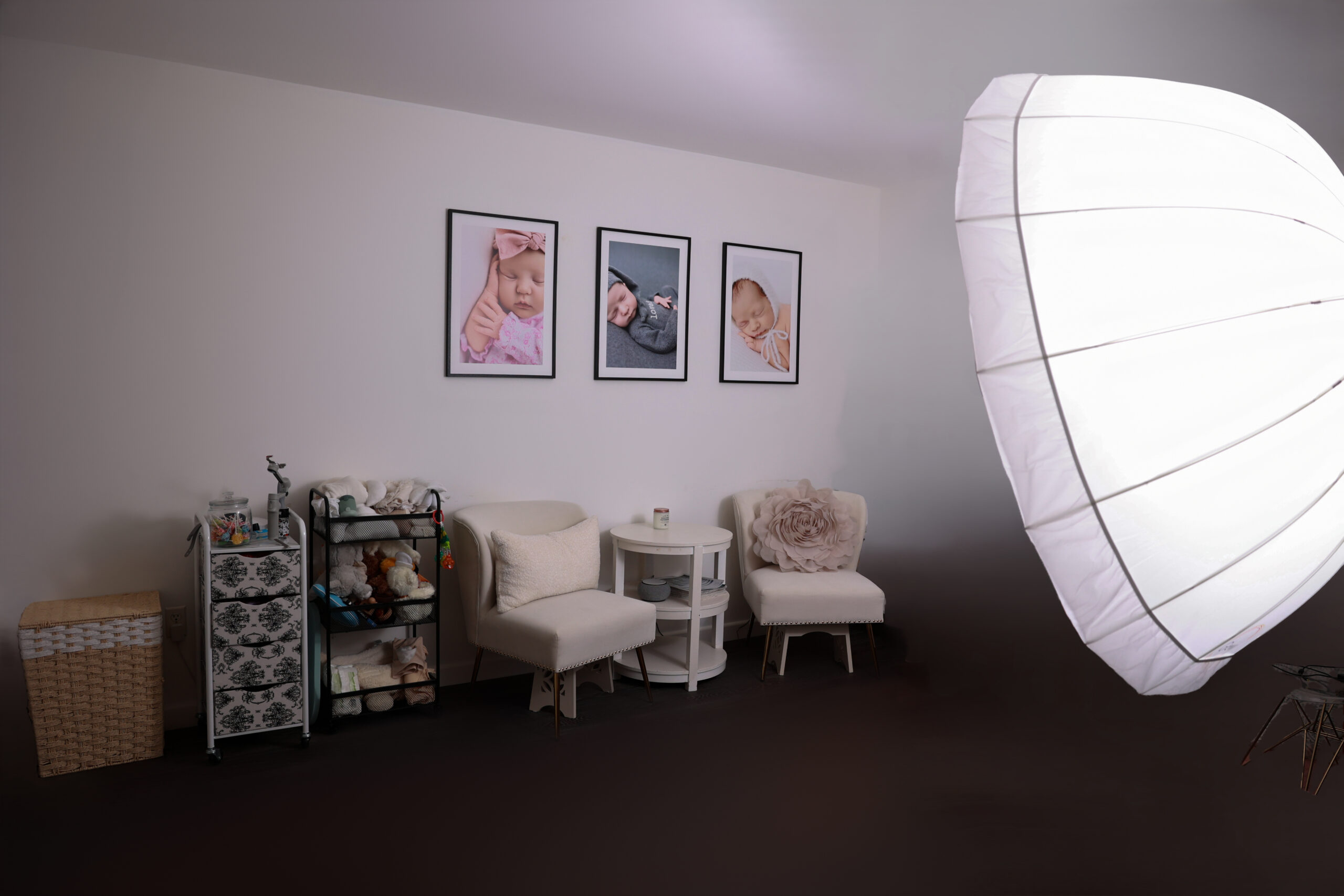 Photography studio in Redondo Beach showing images of babies on the wall and a sitting area for the parents.