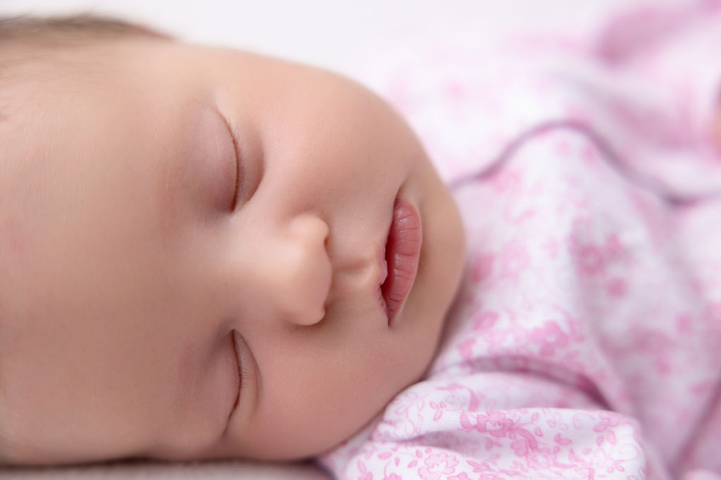 Details of a sleeping newborn girl's face and lips